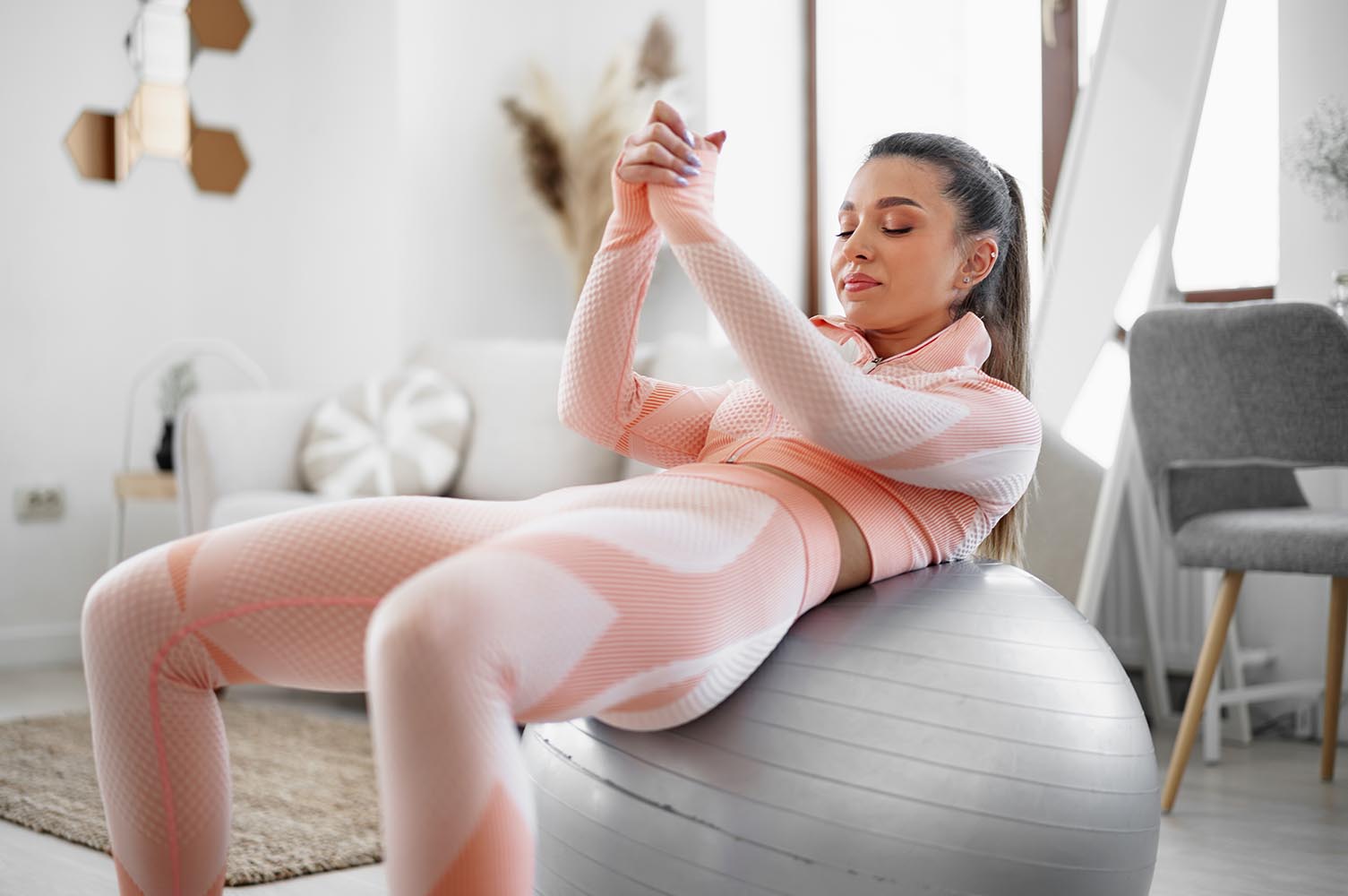 mujer haciendo abdominales sobre una pelota de pilates