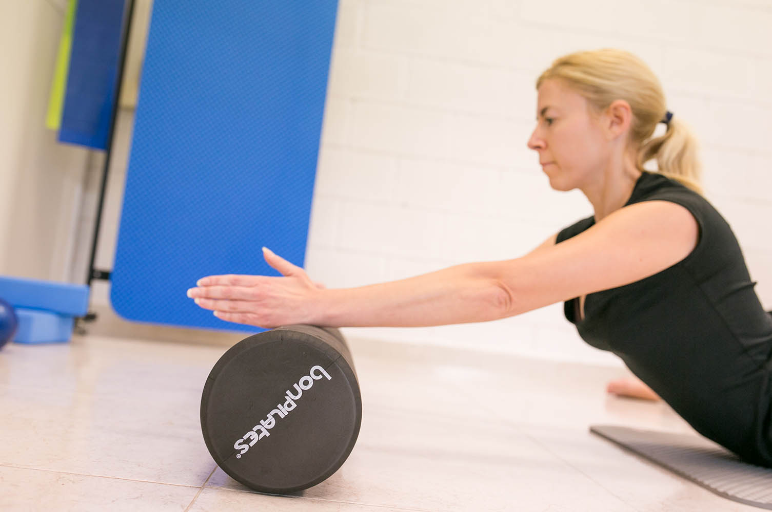 mujer haciendo pilates utilizando un foam roller en su entrenamiento.