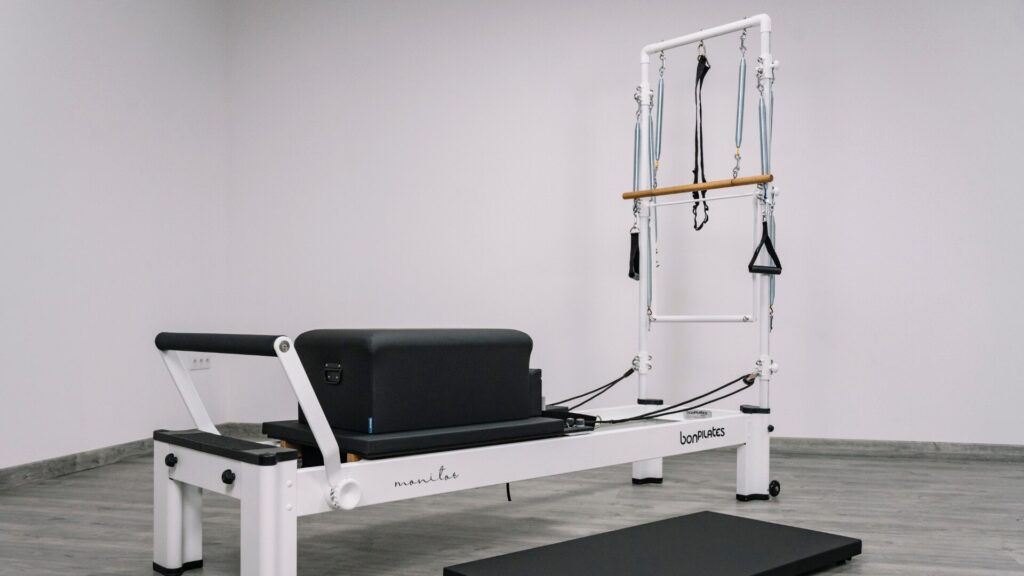 Máquina híbrida de Pilates que combina Reformer y Cadillac en una sala de entrenamiento.