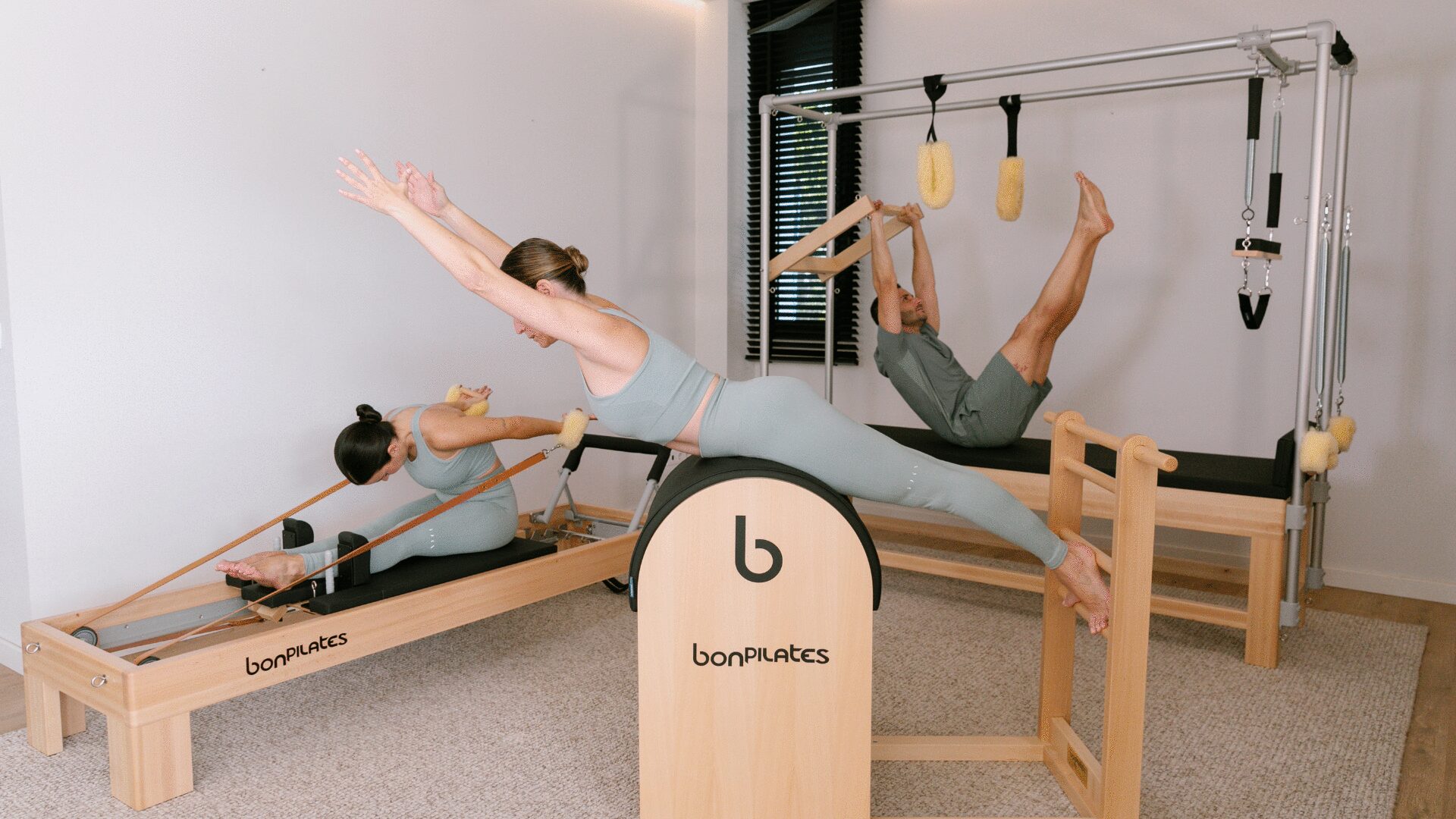 Variedad de aparatos de Pilates de madera en una sesión de entrenamiento personalizado.